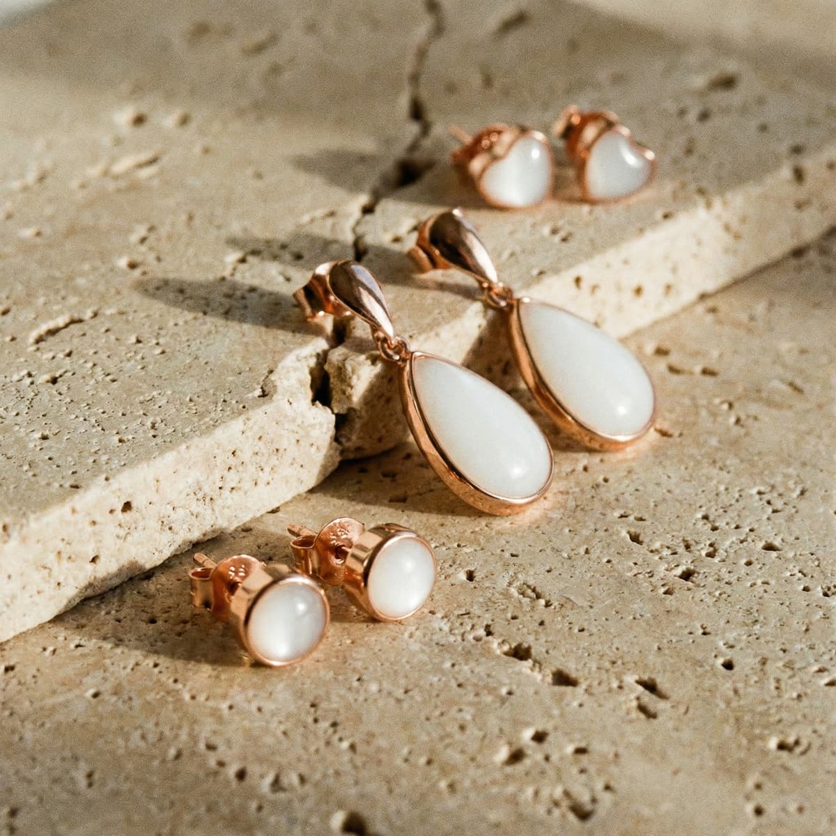 Pendientes elegantes de leche materna en resina blanca con monturas chapadas en oro rosa, tipo studs y lágrima sobre piedra natural, ideales como inspiración sobre como hacer pendientes leche materna en casa.
